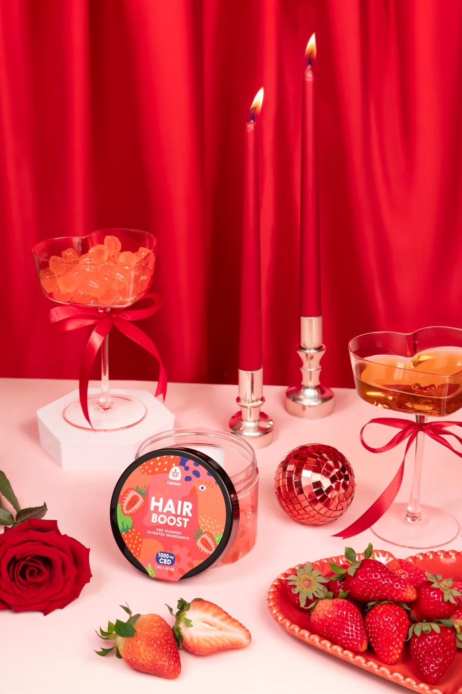 CBDWAY-Produktfotografie mit Erdbeeren in einer roten Szene